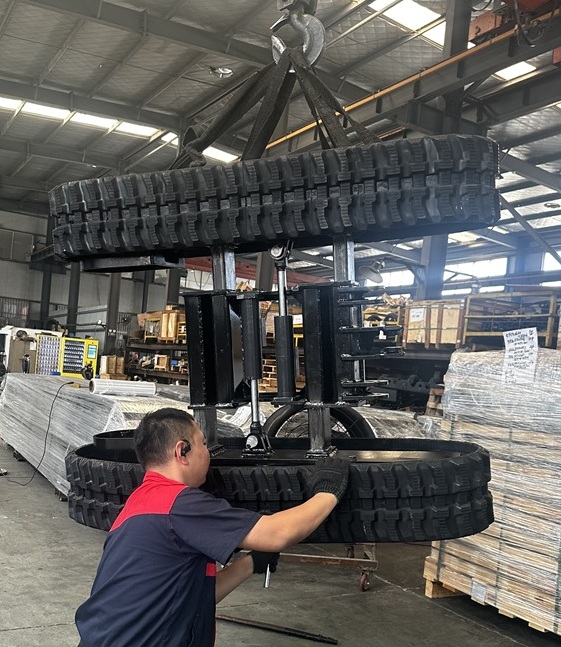 Compact retractable rubber track undercarriage with integrated heavy-duty bulldozer blade for small machinery
