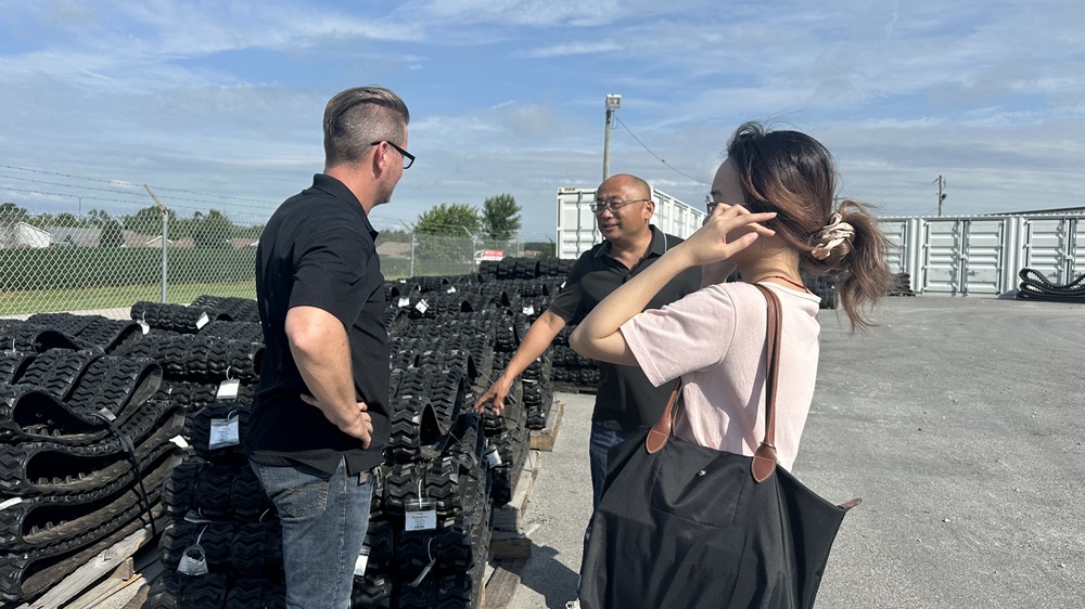 Zhenjiang Yijiang Machinery team conducting on-site technical inspection of premium rubber tracks with a VIP client